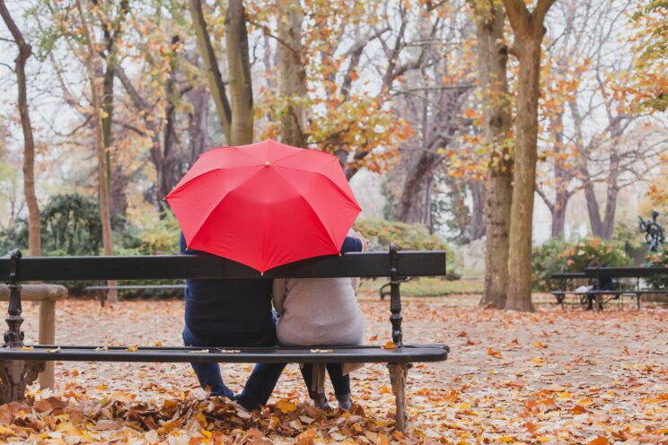 couple under umbrella in autumn park, love